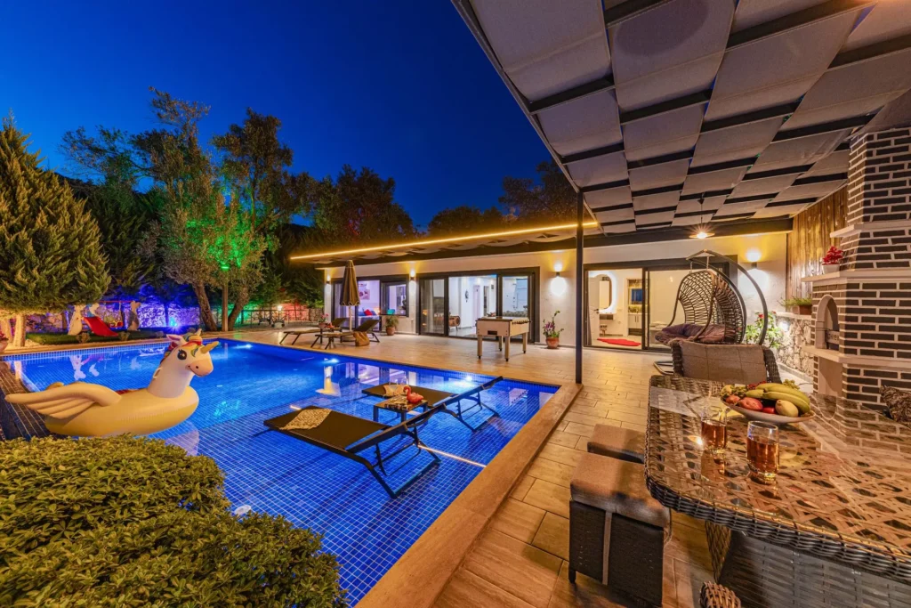 Vacation villa with a lit swimming pool in the evening